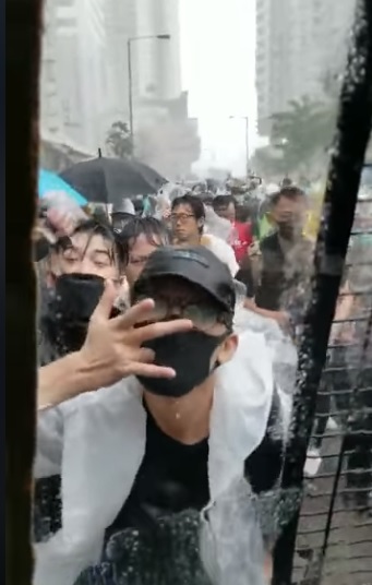 有蒙面人對車上警員做出不文手勢作挑釁。（影片截圖）