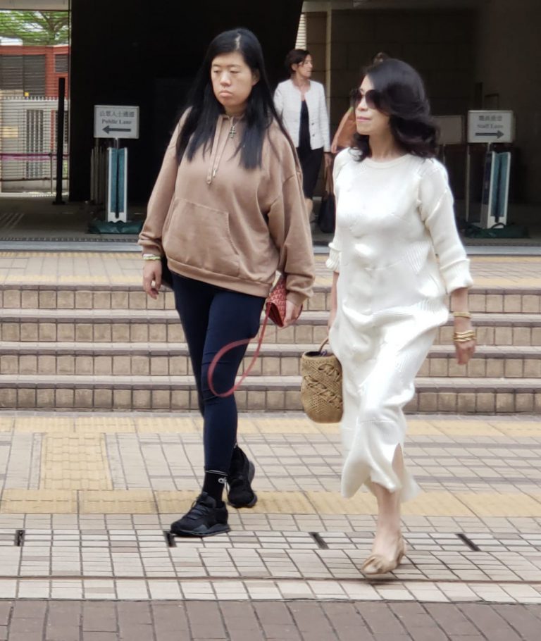 黎妻女散庭後離開；二人在東京街西九龍法院外巴士站駐足等候車輛。(朱先儒攝)
