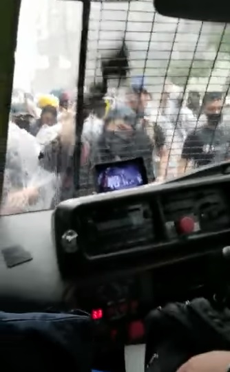 大批蒙面人士在東院外圍攻警車。（影片截圖）