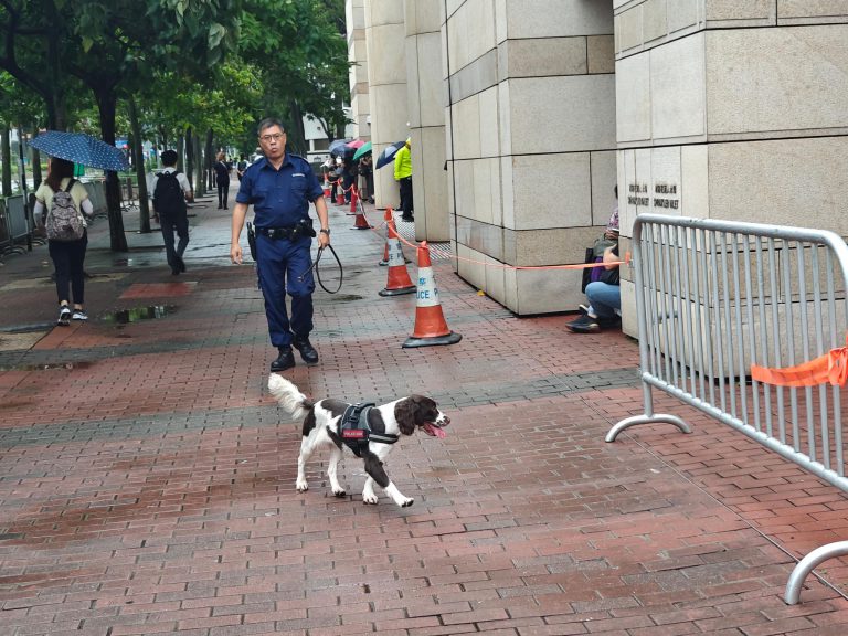 警員攜警犬在法院周邊搜查。（周文虎攝）