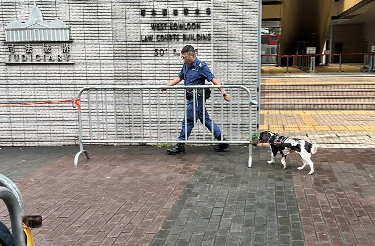 法院外圍一帶加強保安,亦有警員帶同警犬巡查。（燊亮攝）
