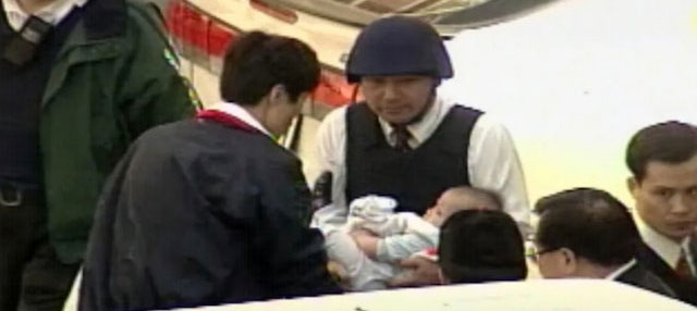 侯友宜於1997年抱著男嬰步出南非武官官邸的經典畫面。(TVBS電視截圖)