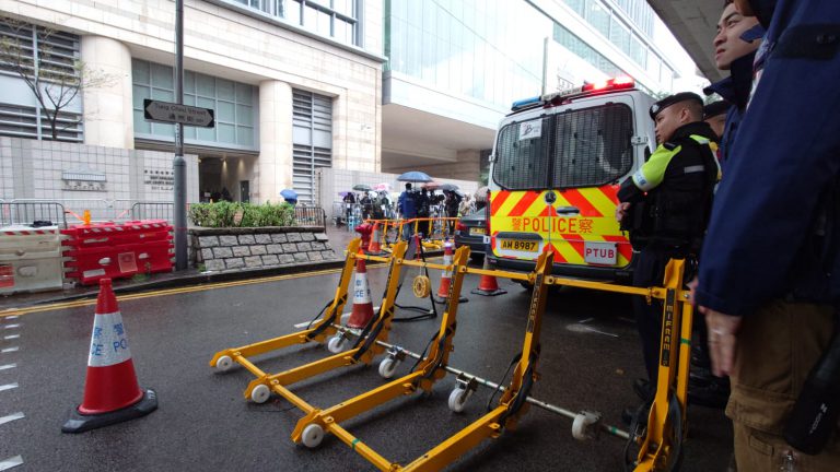 警方在法院外一段通州街架起路障,檢查外來車輛。（堅料網記者攝）
