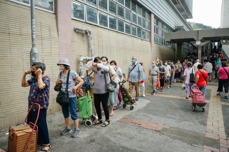 街坊反應熱烈，長龍排到天橋上。（黃冠華攝）